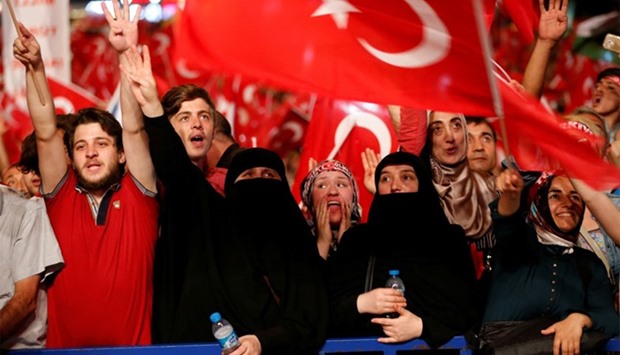 Supporters of Turkish President Tayyip Erdogan shout slogans and wave Turkish national flags during a pro-government demonstration on Taksim square in Istanbul, Turkey