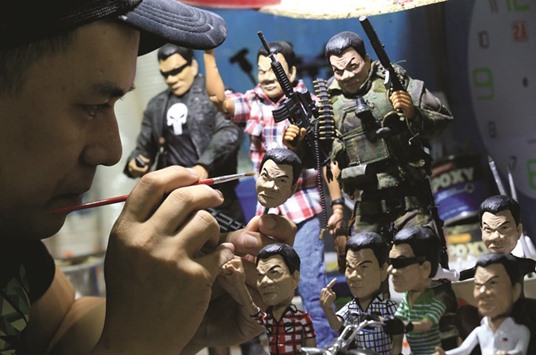 Dennis Mendoza, 36, puts on finishing touches on toy figurines of President Rodrigo Duterte made of fibre resin, which he sells for 800 to 5,000 pesos ($17-106) inside his workshop in Pasay city, Metro Manila.