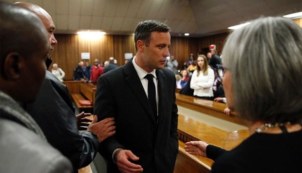 Oscar Pistorius (C) speaking with relatives as he leaves the High Court in Pretoria, on July 6, 2016 after being sentenced to six years in jail.