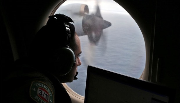 Flight officer Rayan Gharazeddine looks out of a Royal Australian Air Force (RAAF) AP-3C Orion as it flies over the southern Indian Ocean during the search for missing Malaysian Airlines flight MH370 March 22, 2014
