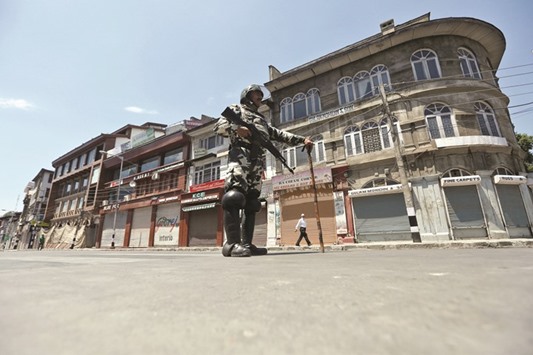 A policeman stands guard during a curfew in Srinagar yesterday.