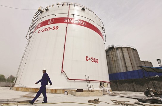 An employee walks past oil tanks at a Sinopec refinery in Wuhan, Hubei province. China imported 4.569mn tonnes of crude from Saudi Arabia in June.