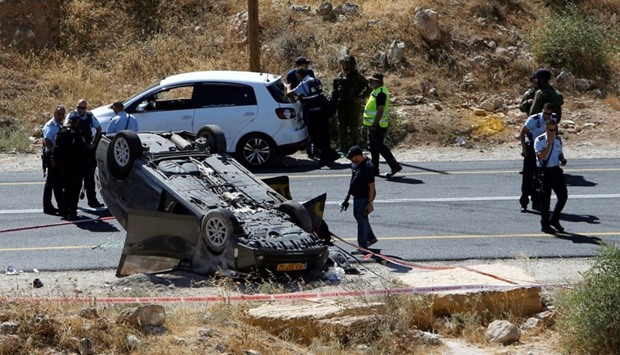 Israeli security forces gather at the scene following a shooting on an Israeli car near the West Bank city of Hebron yesterday.