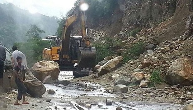 Bulldozers remove the debris from National Highway-94