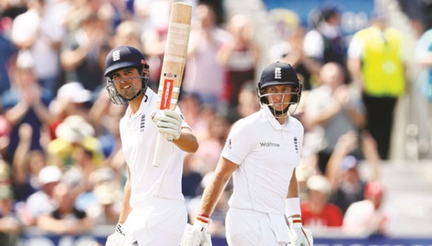Englandu2019s Alastair Cook celebrates his half century as Joe Root looks on during the first day of the second Test match against Pakistan at Old Trafford in Manchester yesterday.