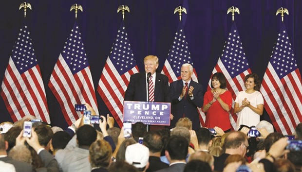 Republican presidential candidate Donald Trump speaks as vice presidential candidate Mike Pence and his wife Gail Pence and daughter Charlotte Pence watch at a post Republican Convention campaign event in Cleveland, Ohio, yesterday.
