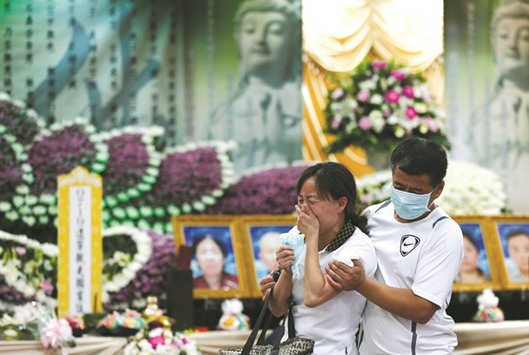 Family members of the bus fire victims cry as they attend a funeral in Taoyuan, Taiwan late on Thursday.