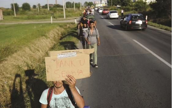 A migrant holds a placard reading u2018Thank you Serbiau2019 he walks among others near Belgrade towards the Serbian border with Hungary.