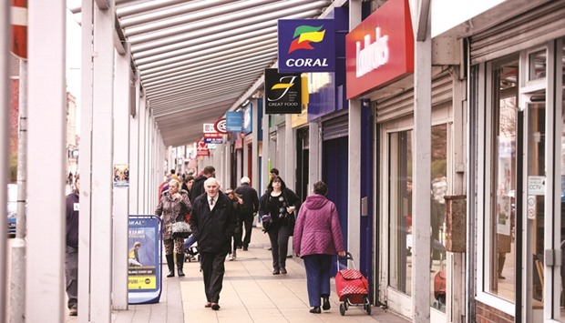 Shoppers pass along a shopping mall in Port Talbot, the UK. Britainu2019s economy is shrinking, the broadest survey of business confidence since last monthu2019s historic vote to quit the European Union showed yesterday.