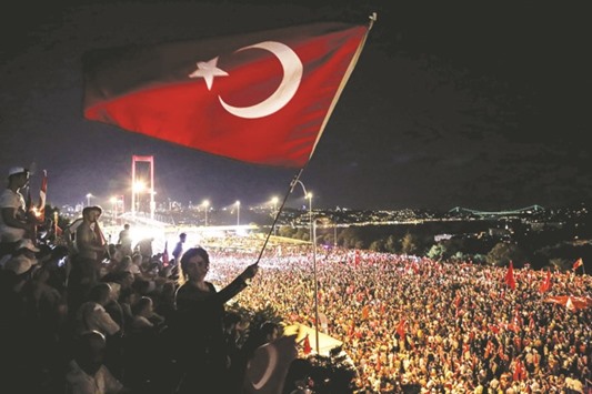 Pro-Erdogan supporters waving a Turkish national flag during a rally at Bosphorus bridge in Istanbul on Thursday. Thousands of Turkish government supporters on Thursday streamed across one of the two bridges spanning the Bosphorus in Istanbul to protest against the coup that sought to unseat President Recep Tayyip Erdogan one week ago.