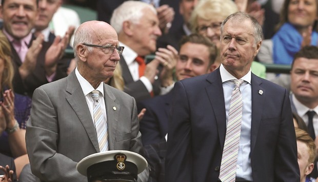 Former England footballers Bobby Charlton (left) and Geoff Hurst stand in the royal box on centre court as they are introduced at Wimbledon yesterday. (AFP)