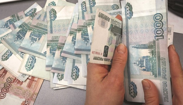 An employee counts rouble banknotes at a shop selling home appliances in Krasnoyarsk. The roubleu2019s 15% rally on the back of a rebound in oil marked the best first half for the Russian currency since at least 2004.
