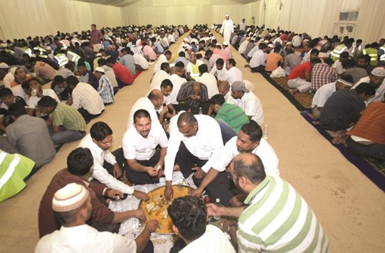 People breaking the fast at a community Iftar tent.