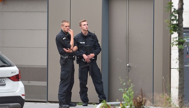 Policemen stand in front of an apartment building in Munich's Dachauer Strasse street , one day after the attack at the shopping centre in Munich.