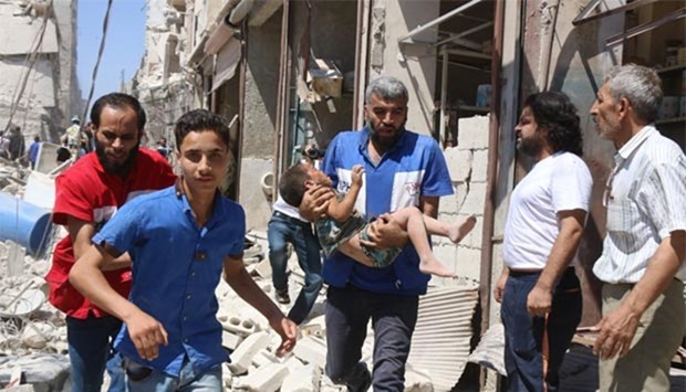A Syrian civil defence volunteer carries a wounded child following a reported airstrike in Aleppo on Saturday.