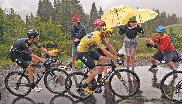 Britain's yellow jersey leader Chris Froome of Team Sky rides as a fan takes a picture during the 146.5km 20th stage from Megeve to Morzine, France of the Tour de France cycling race yesterday.