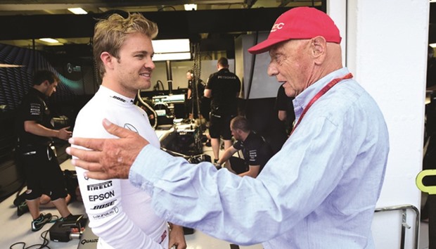 Mercedes driver Nico Rosberg (left) listens to Formula one legend and team adviser Niki Lauda in front of their pit lane prior to the qualifying session in Hungaroring, near Budapest yesterday.