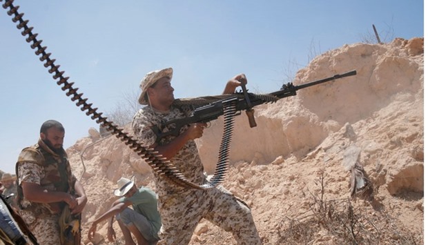 A fighter of Libyan forces allied with the UN-backed government fires a weapon during a battle with IS fighters in Sirte, Libya, on July 21, 2016.