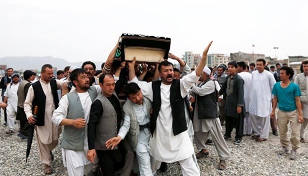 Afghan men carry the coffin of a victim of a suicide attack in Kabul, on Sunday.