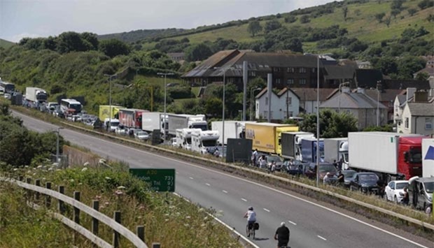 Traffic stands still with travellers resting outside their vehicles on the main road leading into the port of Dover on the south coast of England on Sunday.