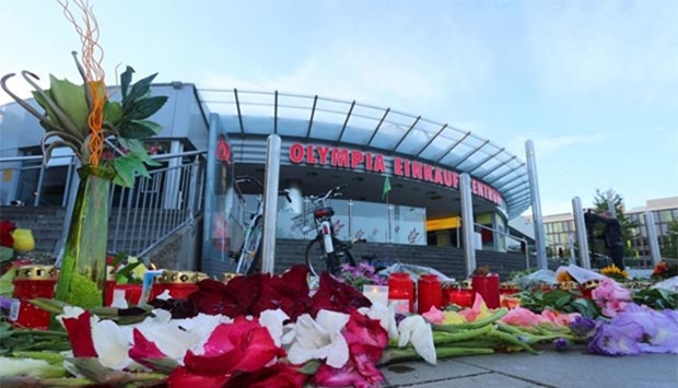 A memorial of candles and flowers is laid down in front of the Olympia shopping centre in Munich, where an 18-year-old German-Iranian student ran amok.