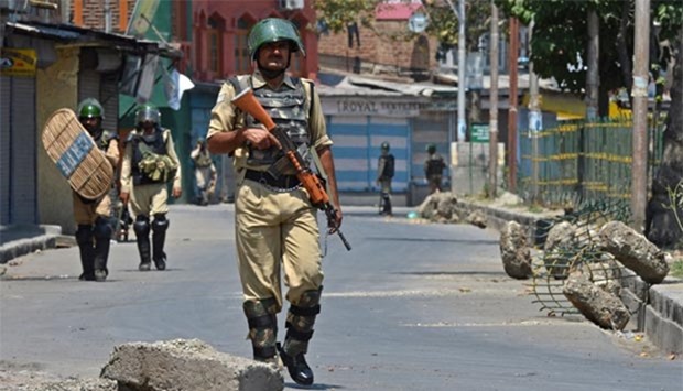 An Indian paramilitary soldier patrols during a curfew in downtown Srinagar on Sunday.