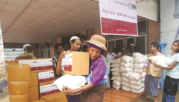 Myanmarese families receiving food aid from QRCS.