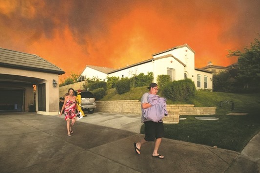 Residents flee their home as flames from the Sand Fire close in near Santa Clarita.