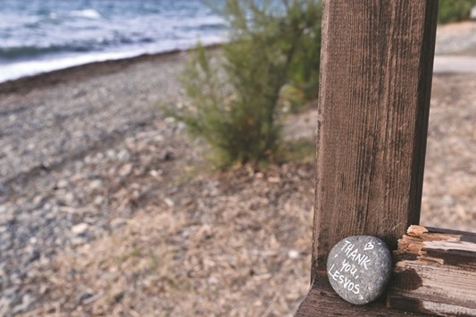 A stone is kept on the empty Eftalou beach near the resort of Molyvos on the Greek island of Lesbos.