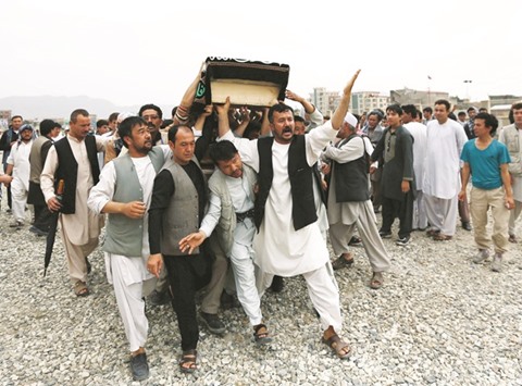 Men carry the coffin of a victim a day after a suicide attack in Kabul yesterday.