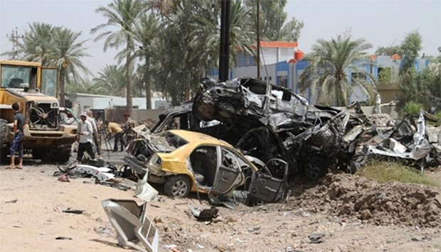 Iraqis inspect the damage at the site of a suicide bomb attack in Khales, 80 kms northeast of Baghdad, on Monday.