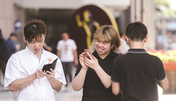 People use their mobile phones to play Nintendou2019s Pokemon Go game in Hong Kong. Nintendo shares plunged yesterday after it warned that the Pokemon Go mania sweeping the world would not translate into bumper profits, popping a dizzying rally that more than doubled the Japanese firmu2019s market value.