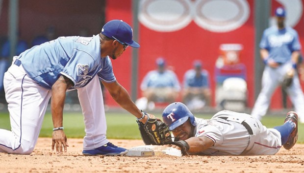 Texas Rangersu2019 Delino DeShields teals second,sliding past the base and back on before the tag from Kansas City Royals shortstop Alcides Escobar in the third inning at Kauffman Stadium in Kansas City.