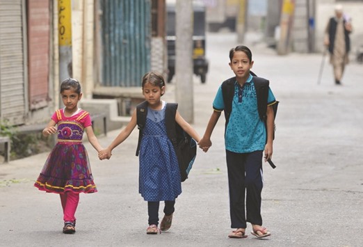 Schoolchildren walk toward their home in Srinagar yesterday. Kashmir has been under a curfew following the death of rebel commander Burhan Wani in a gunfight with security forces on July 8.
