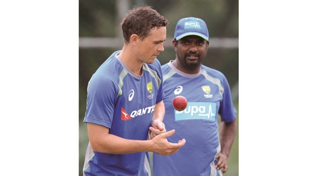 Australiau2019s bowling consultant, Sri Lankan former cricketer Muttiah Muralitharan (R) speaks with Australian spinner Stephen Ou2019Keefe during a practice session at the Pallekele International Cricket Stadium in Pallekele yesterday.