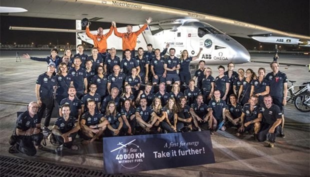 Swiss pioneer Bertrand Piccard (top right) and Andre Borschberg (top left) pose with their team after landing in Abu Dhabi on Tuesday at the end of their world tour.