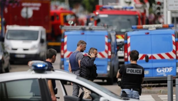 French police officers and firemen arrive at the scene of a hostage-taking at a church in Saint-Etienne-du-Rouvray, northern France, on Tuesday that left the priest dead.