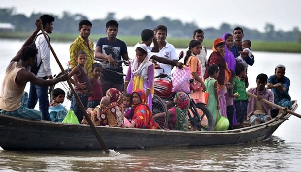 Indian villagers travel by boat over floodwaters in Ashigarh village in the Morigoan district of Assam.