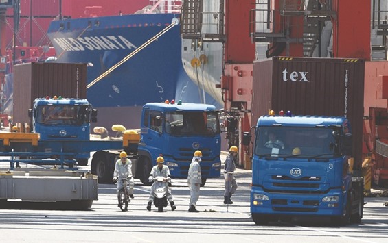 Trucks are seen transporting containers from a port in Tokyo. Japan expects to have a primary deficit of u00a59.2tn if growth remains weak, and to fail to reach its target of a primary budget surplus even in fiscal 2024, the Cabinet Office said yesterday.