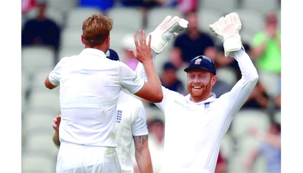 Englandu2019s  Stuart Broad (L) celebrates with Englandu2019s  Jonathan Bairstow (R) after taking the wicket of Pakistanu2019s Asad Shafiq on the third day of the second Test match in Manchester on Sunday.