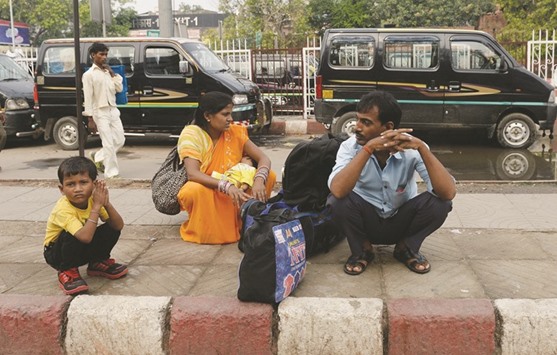 A family waits for transport as taxis on strike are parked at the main railway station in New Delhi yesterday.