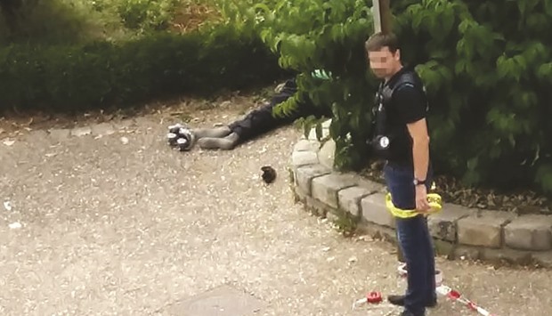 A police officer cordons the site next to the body of one of the two men who stormed a French church and slit an elderly Catholic priestu2019s throat in the Normandy town of Saint-etienne-du-Rouvray.