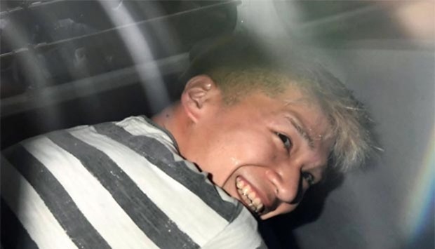 Satoshi Uematsu, suspected of a deadly attack at a facility for the disabled, is seen inside a police car as he is taken to prosecutors in Sagamihara, Kanagawa prefecture, on Wednesday.