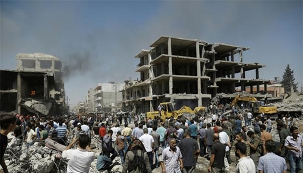 Syrians gather at the site of a bomb attack in the northeastern city of Qamishli on Wednesday.