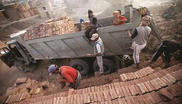 Labourers load mud bricks onto a truck at a brick factory on the outskirt of Sanaa.
