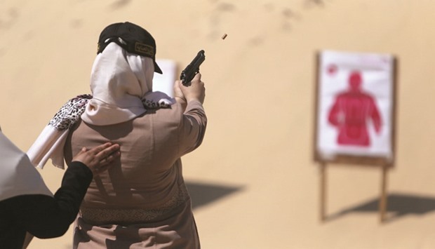 A Palestinian woman fires at a target during a training session for the families of Hamas officials, organised by Hamas-run Security and Protection Service, in Khan Younis in the southern Gaza Strip.