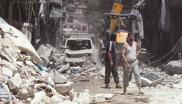 Residents inspect a damaged site after an air strike on Aleppou2019s rebel held Al-Mashad neighbourhood yesterday.