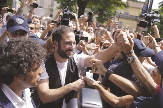 Juventusu2019 forward Gonzalo Higuain from Argentina shakes hands with supporters near the Juventusu2019 headquarters in Turin yesterday.