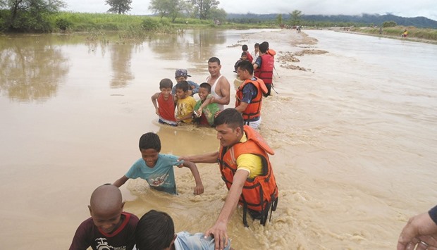 Police personnel guiding children through floodwaters at Babai Muinicipality-7 in Bardiya, some 400kms southwest of Kathmandu, yesterday.
