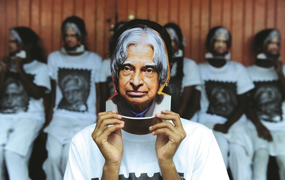 Schoolchildren hold masks bearing the image of former president A P J Abdul Kalam during a remembrance event on the first anniversary of his death, in Chennai yesterday.